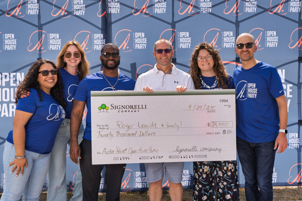 Roger Leavitt and family posing with a $20,000 prize check at Austin Point Open House Party.
