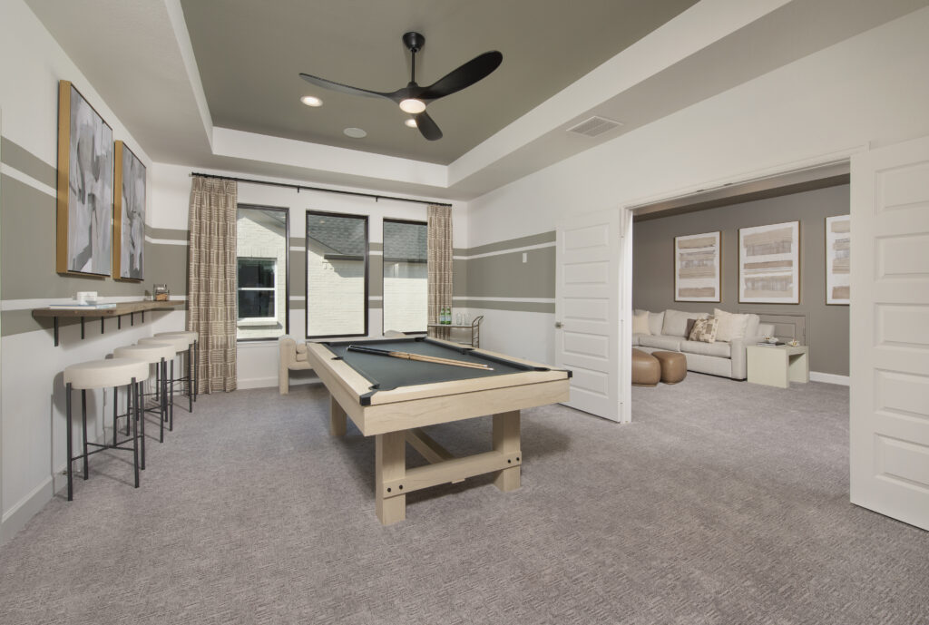 Game room with pool table and bar seating in Perry Homes 60' model home at Austin Point