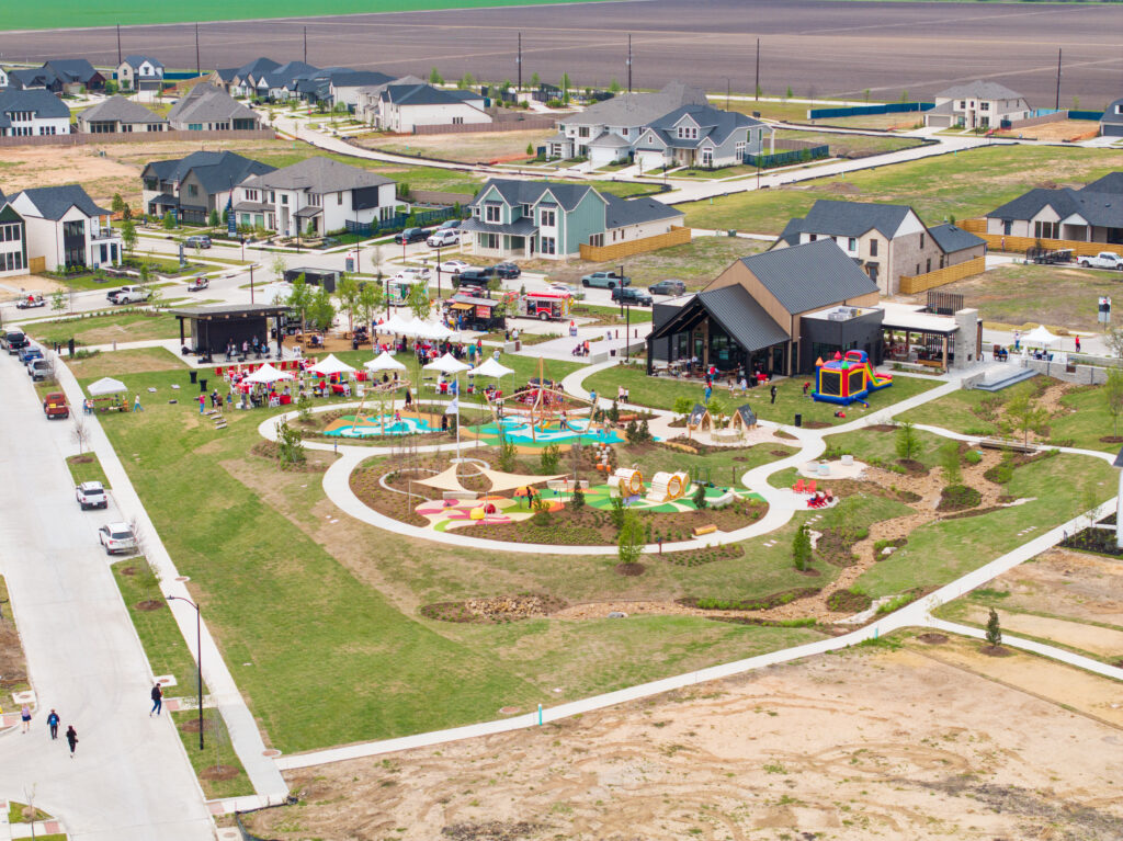 Aerial view of the civic green, playground, and The 1824 during the Paint This Town Red grand opening at Austin Point.