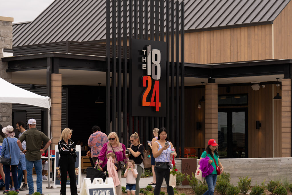 Visitors gather outside The 1824 social hub during the Paint This Town Red grand opening event at Austin Point in Fort Bend County.