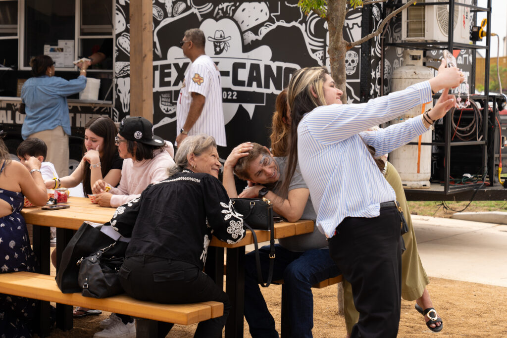 Guests enjoying food and taking photos near food trucks during the Austin Point grand opening festival.