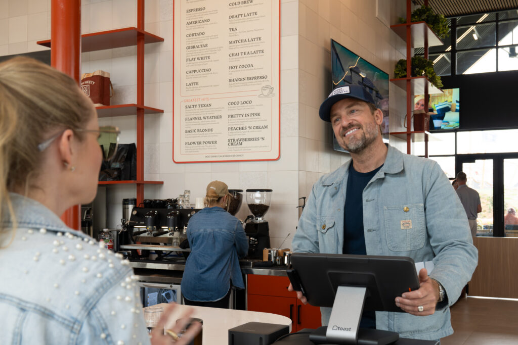 Billy Schiel prepares coffee at Honor Society at The 1824 during the Paint This Town Red grand opening festival at Austin Point.