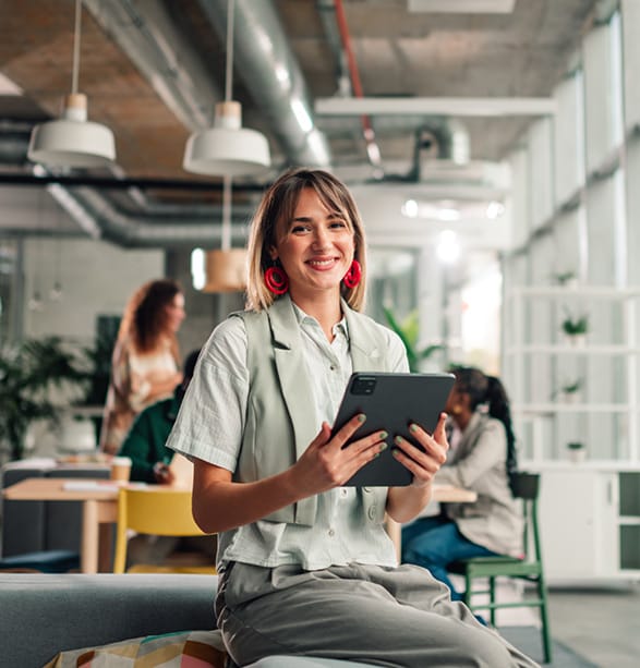 A business woman in an office holding a tablet